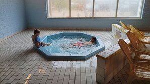 Un bain à remous pour deux personnes, un sol carrelé et une fenêtre avec vue.