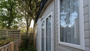 A wooden deck leading to a house with a sliding glass door. - Chalet in Renesse Near Sandy Beaches (Renesse)