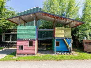 A colorful, multi-level wooden structure with a metal roof, surrounded by greenery. - Peaceful Retreat Near Zeeland Beach (Vrouwenpolder)