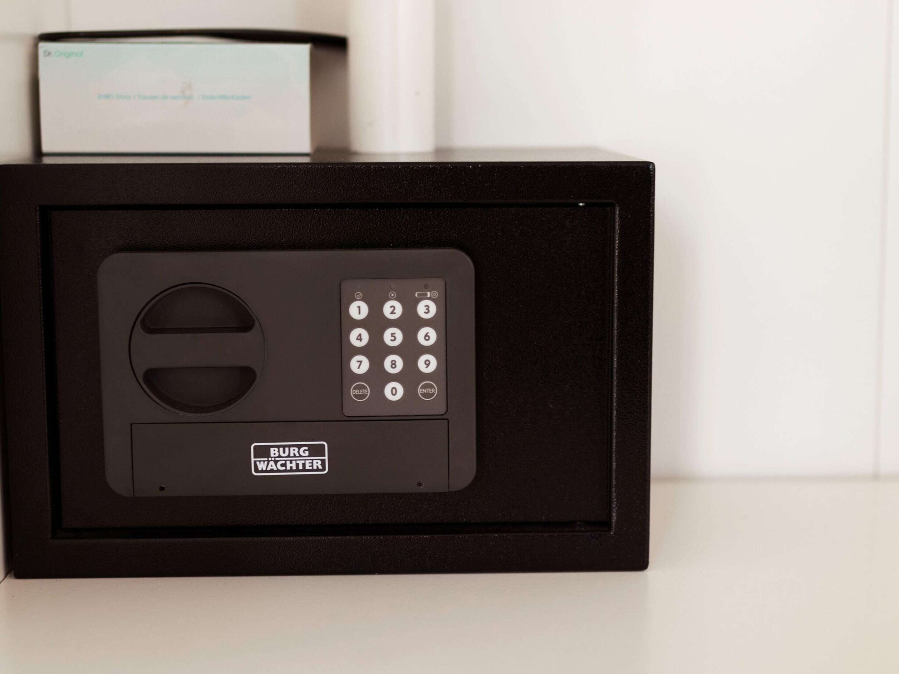 A black safe with a keypad and a label that reads "BURG WACHTER".