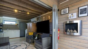 A cozy interior with a dining area, a sofa, a TV, and a fireplace. - Romantic Chalet Near Wilhelminadorp (Wilhelminadorp)