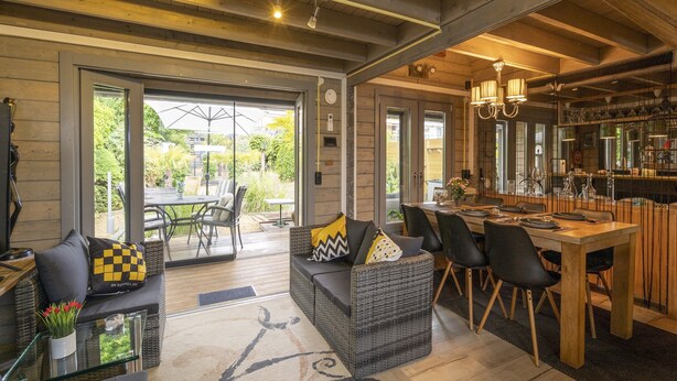 A spacious living area with a dining table, comfortable seating, and a view of the outdoors. - Romantic Chalet Near Wilhelminadorp (Wilhelminadorp)