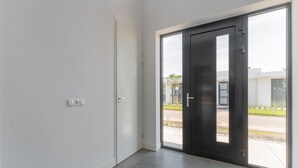 A modern interior with a large sliding glass door leading to an outdoor area. - Villa in Zeewolde for 6 Person (Zeewolde)