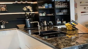 A modern kitchen with a granite countertop, stainless steel appliances, and a built-in sink. - Exclusive Villa With Boat Terrace (Zeewolde)