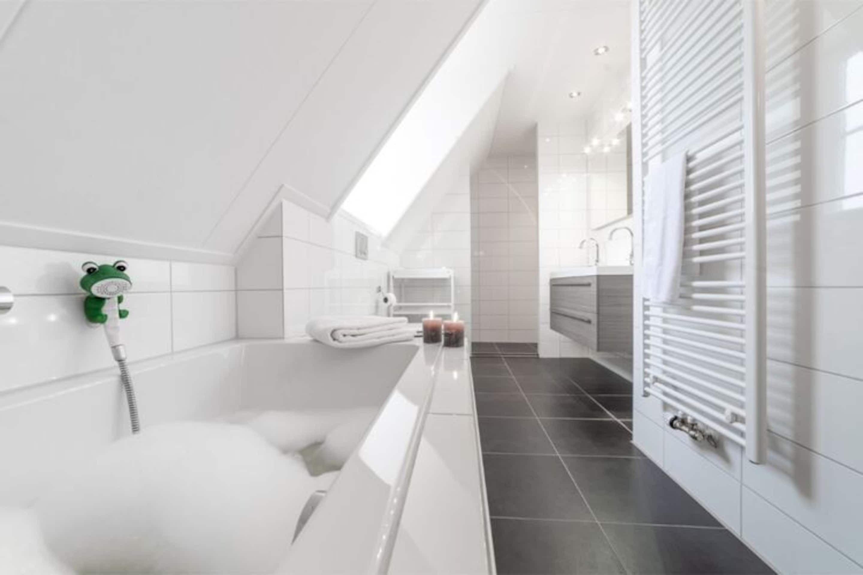 Ein modernes Badezimmer mit einer Badewanne, einer Dusche und einem Handtuchhalter.
