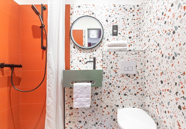 A bathroom with a shower, a toilet, a sink, and a mirror. - SEAKUB HOTEL (Royan)