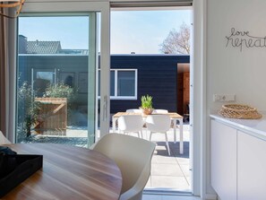 A modern interior with a sliding glass door leading to a patio area. - Farmhouse in Zeeland With Saltwater Pool (Oostkapelle)