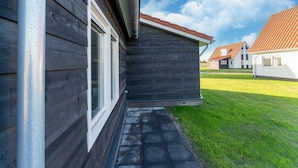 A residential building with a dark wooden exterior, a visible window, and a red-tiled roof. - House Near Scherpenisse Beach With Garden (Scherpenisse)