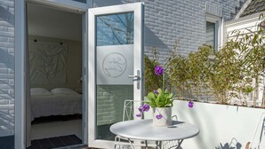 A modern room with a bed, a small table with a potted plant, and a chair. - Holiday Home in Oostkapelle Near the Beach (Oostkapelle)