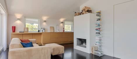 Un salon moderne avec un canapé, une table basse et une bibliothèque.