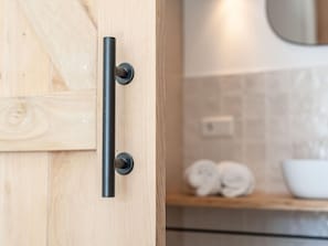 Une porte en bois avec une poignée noire et un porte-serviettes avec des serviettes.