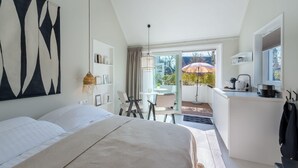 Un dormitorio con una cama grande, un escritorio y vistas al exterior.