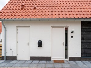 A building with two white doors, a black mailbox, and a number '45' sign on the wall. - Beach Bliss Romantic Retreat (Scherpenisse)