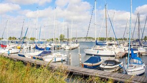 A marina with numerous sailboats docked at wooden piers. - Holiday Home Near Veerse Meer (Kamperland)