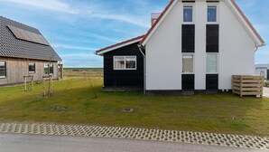 A two-story house with a steeply pitched roof, a small attached garage, and a paved driveway.