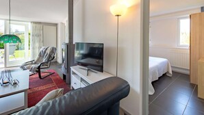 A modern hotel room with a sofa, a TV, a desk, and a bed. - House Near Veerse Meer and North Sea Beach (Kamperland)