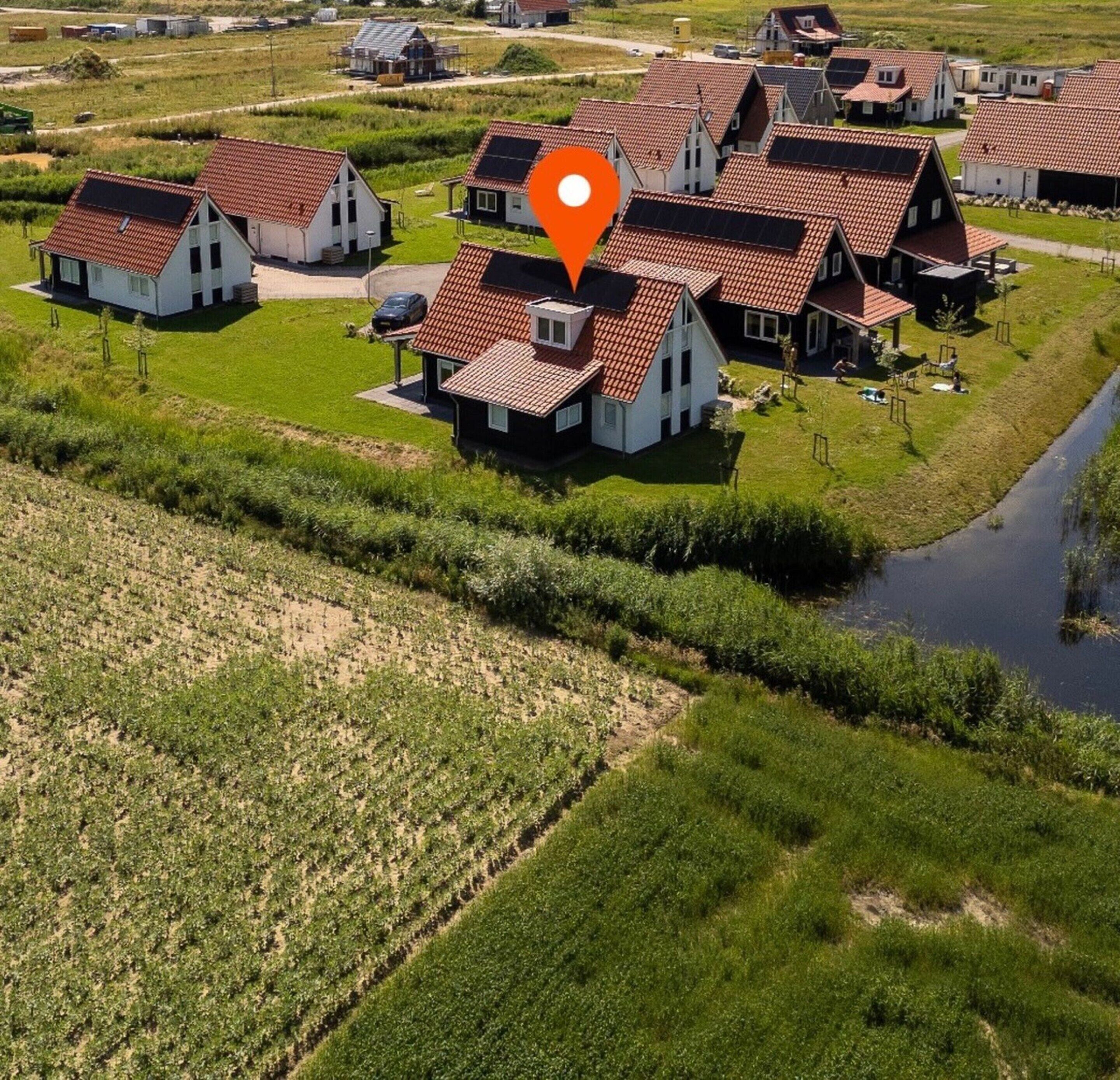 Une zone rurale comprenant plusieurs maisons, une rivière et des champs agricoles.