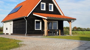 A black house with a red roof and solar panels. - Vacation Home Zeeland by Oosterschelde Park (Scherpenisse)