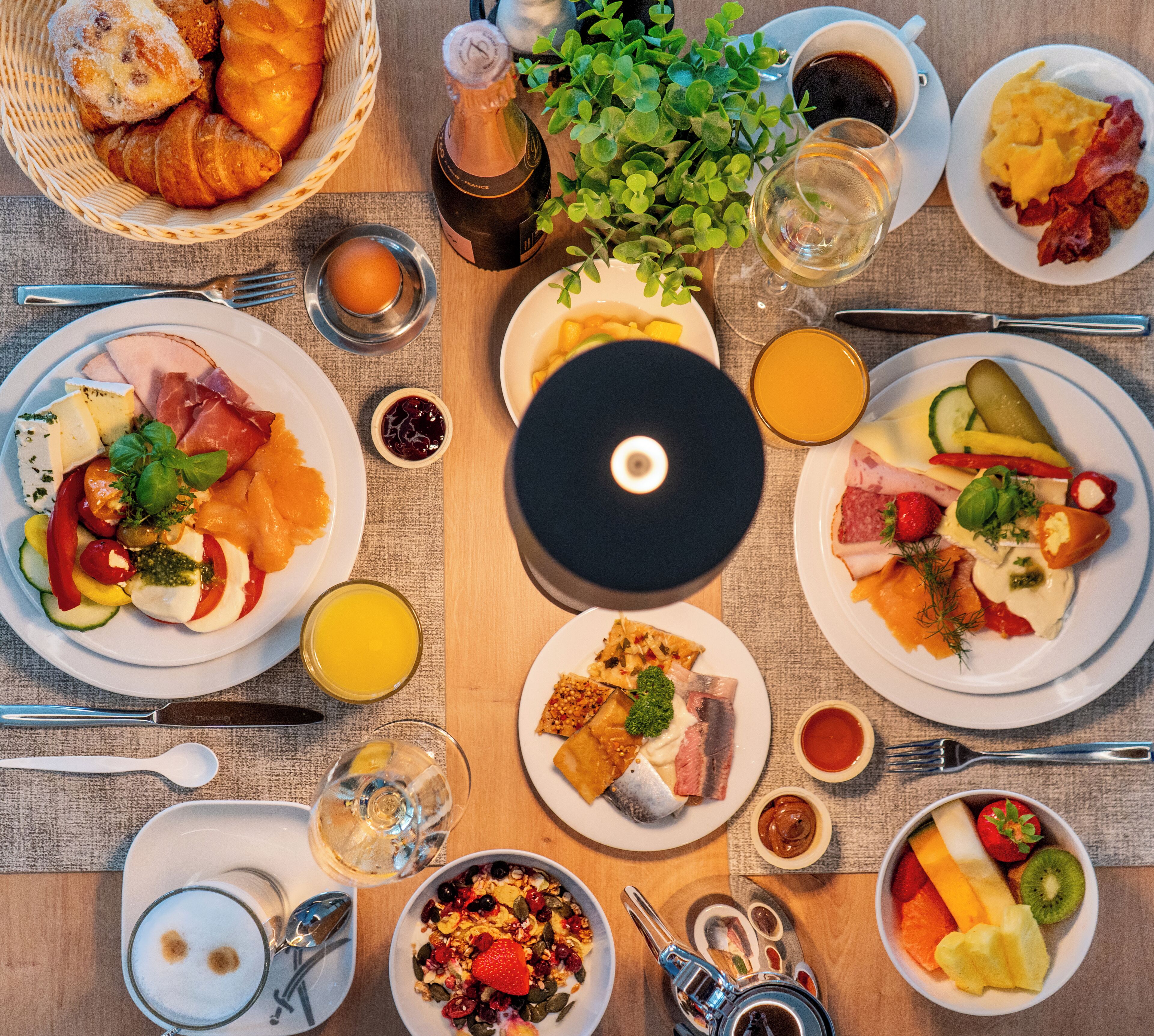 A breakfast buffet with various dishes, drinks, and a CD player.