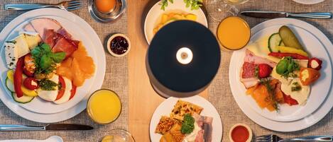 A breakfast buffet with various dishes, drinks, and a CD player.