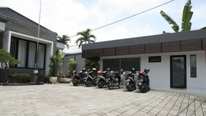 Un edificio moderno con un patio empedrado y varias motocicletas estacionadas.