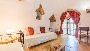 A cozy bedroom with a bed, a chair, and a window with curtains. - Villa Ignatia: A charming villa surrounded by vineyards and olive groves, with Free WI-FI. (Racale)