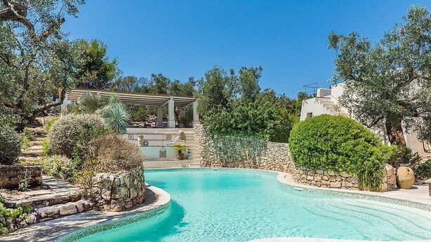 A pool surrounded by stone walls and greenery, with a pergola and steps leading up to a building. - Villa Ignatia: A charming villa surrounded by vineyards and olive groves, with Free WI-FI. (Racale)