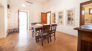 A spacious dining area with a wooden table and chairs, a bench, and a built-in shelf with decorative items.