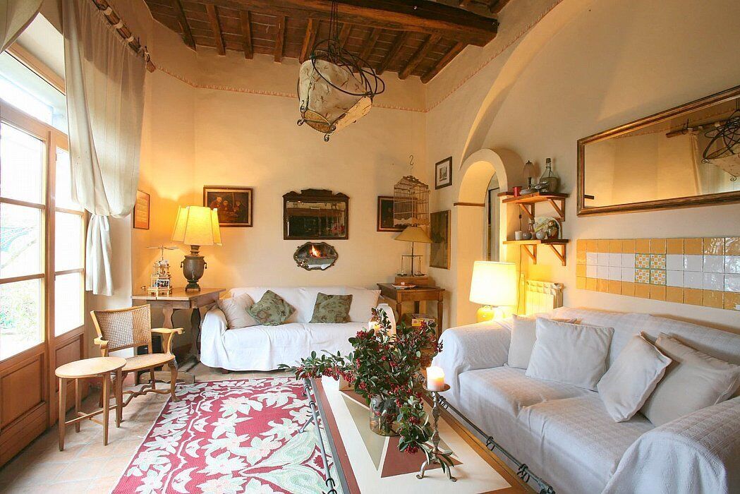 Una habitación acogedora con una cama, dos sofás, una mesa de madera y un amplio ventanal con cortinas.