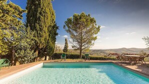 A rectangular pool with a clear blue water surface, surrounded by a wooden deck. - Villa Al Borgo: A welcoming two-story villa located in a characteristic village, with Free WI-FI. (Radda in Chianti)