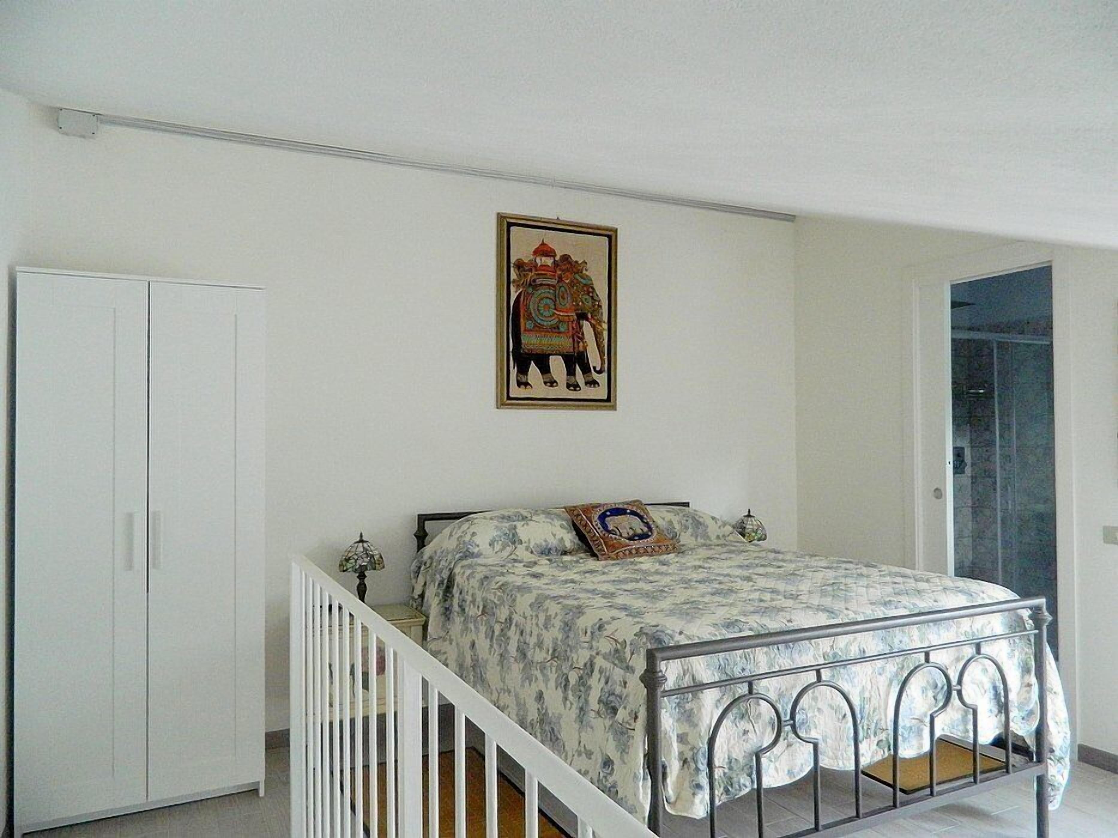 Une chambre à coucher avec un lit, une armoire et une porte.