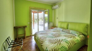 A room with a bed, a bench, and a sliding glass door leading to an outdoor area. - Casa Nilla: A cheerful two-story townhouse situated in a quiet location, a few minutes from the town center, with Free WI-FI. (Agropoli)