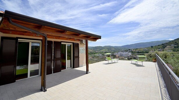 A balcony with a view of the countryside, a wooden pergola, and a seating area with two chairs. - Casa Nilla: A cheerful two-story townhouse situated in a quiet location, a few minutes from the town center, with Free WI-FI. (Agropoli)