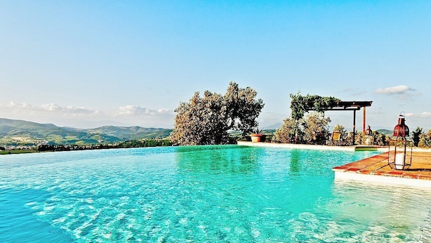 A clear blue infinity pool with a pergola and a lantern on the right side. - Villa Collarina Grande: An elegant and welcoming two-story age-old farm house surrounded by the greenery, with Free WI-FI. (Montelupo fiorentino)