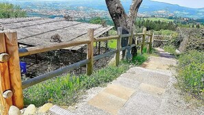 A wooden staircase leading to a viewing platform with a wooden railing, surrounded by greenery and a distant cityscape. - Villa Collarina Grande: An elegant and welcoming two-story age-old farm house surrounded by the greenery, with Free WI-FI. (Montelupo fiorentino)