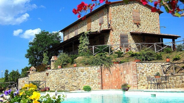 Un edificio de piedra con una piscina delantera.