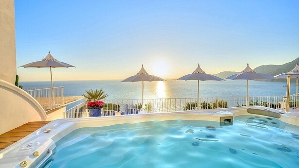 A hot tub with a view of the sea, surrounded by umbrellas and potted plants. - Villa Atena: A charming two-story villa which faces the sun and the sea, with Free WI-FI. (Praiano)