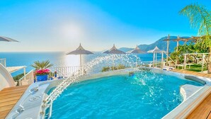 A hot tub with a view of the sea, surrounded by umbrellas and lounge chairs. - Villa Atena: A charming two-story villa which faces the sun and the sea, with Free WI-FI. (Praiano)