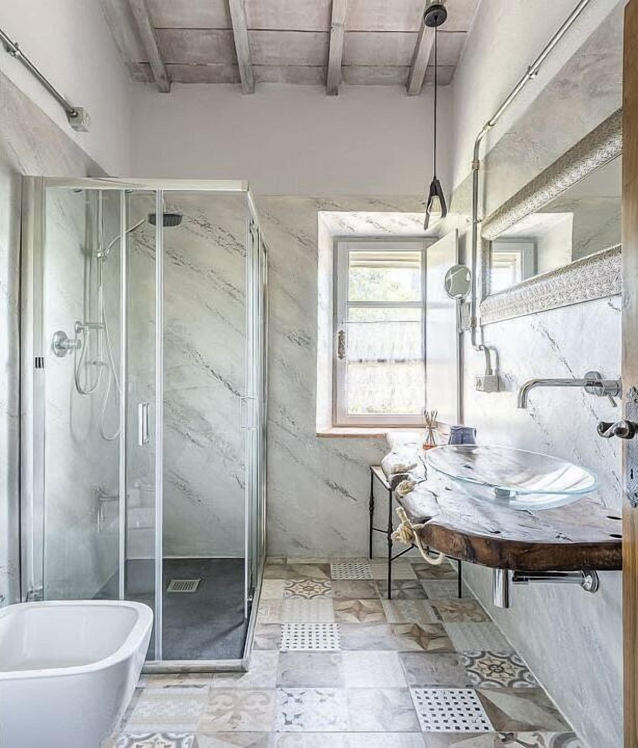 A bathroom with a glass-enclosed shower, a freestanding bathtub, and a vanity with a marble countertop.