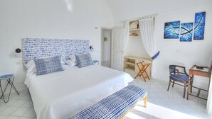 A bedroom with a bed, a desk, and a chair.