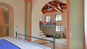 Une chambre à coucher avec un lit, un escalier et une vue sur l’espace de vie.