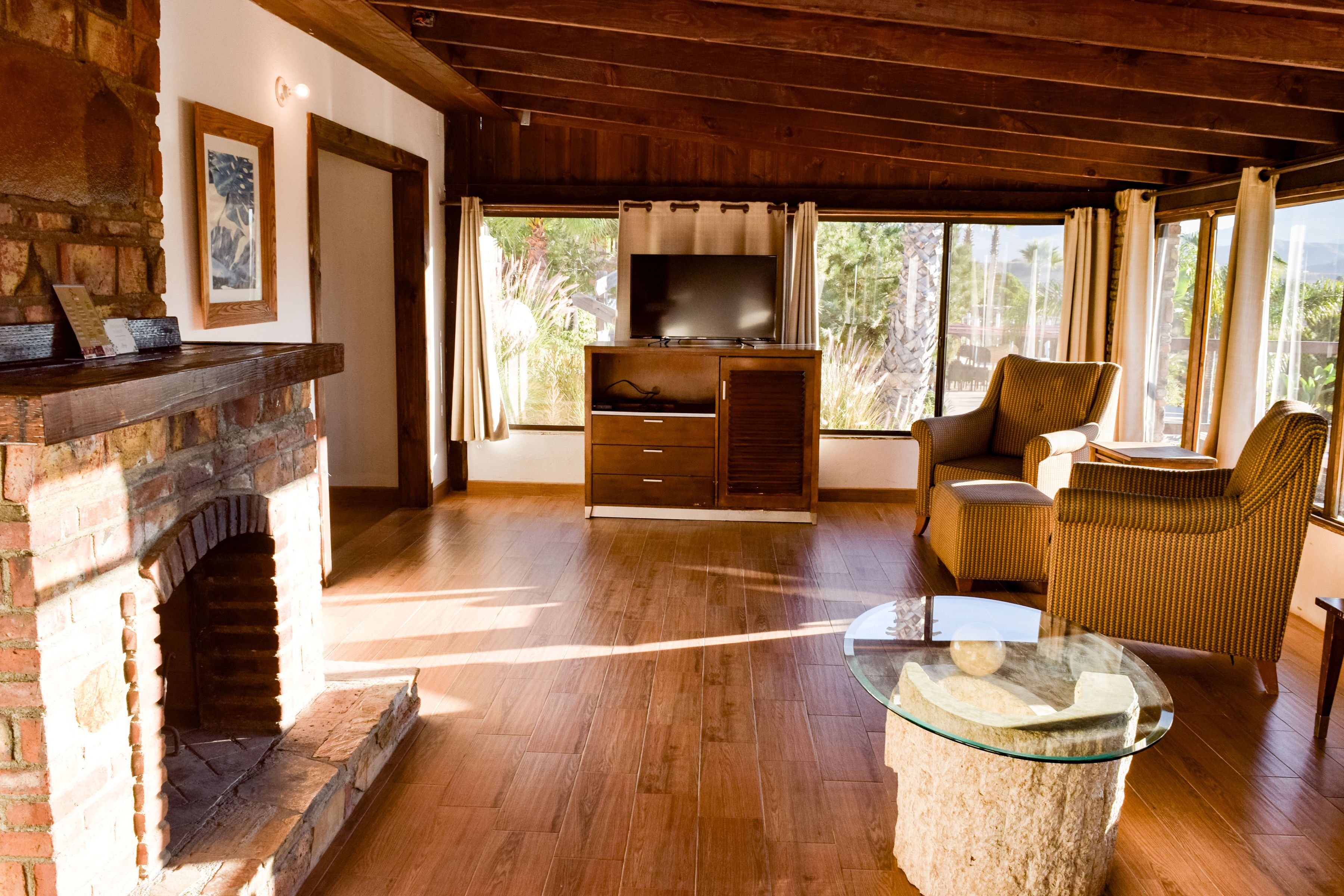 Amplia sala de estar con chimenea, televisor y asientos cómodos.