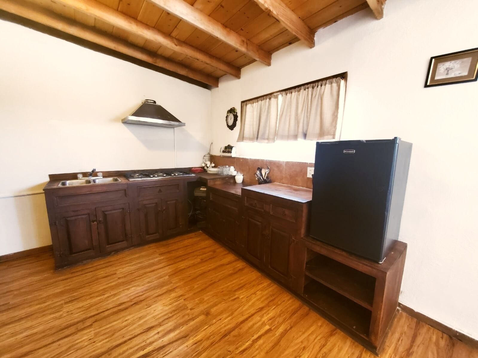 A kitchen with wooden cabinets, a stove, a sink, and a refrigerator.