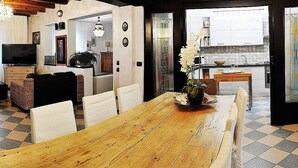 Ein Essbereich mit einem Holztisch, weißen Stühlen und einem Blumenstrauß.