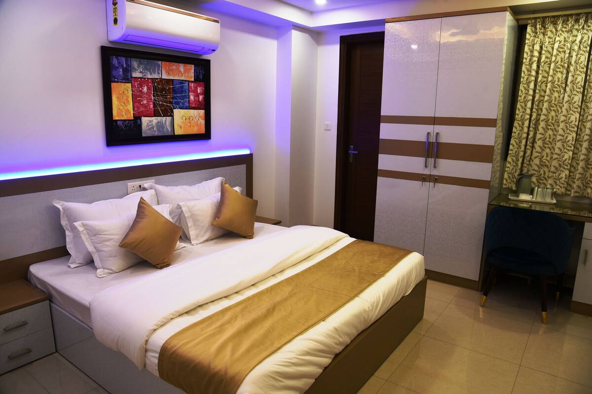 Quarto com cama, mesa de cabeceira e guarda-roupa.