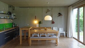 A modern kitchen with a dining area, wooden table, and bench. - House on the Havelbogen directly on the water with canoe and jetty, garden apartment***** (Werder (Havel))