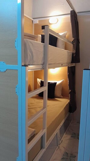 A bunk bed room with a headboard, a small window, and a heater. - High5 Guesthouse (Pattaya)