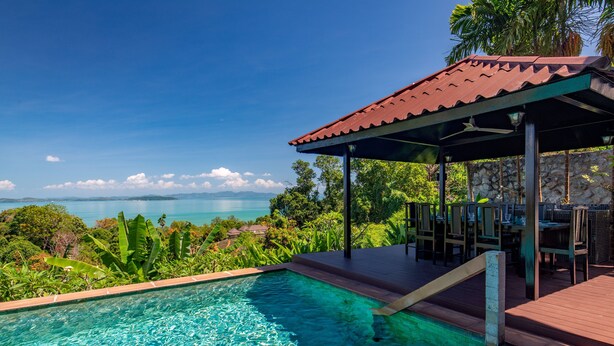 A pool with clear water, surrounded by lush greenery and a view of the sea. - Picturesque 4br Cape Yamu  Pool Villa (Pa Klok)