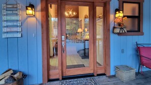 A wooden door with glass panels, a welcome mat, and signs indicating amenities like a ski lodge and powder room. - Four Seasons Getaway-Private Spa-Walk to Village and Pineknot Trailhead-King Bed (Big Bear Lake)