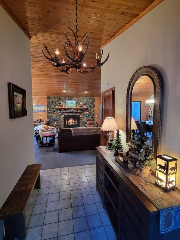 A cozy living area with a fireplace, a wooden ceiling, and a stone wall. - Four Seasons Getaway-Private Spa-Walk to Village and Pineknot Trailhead-King Bed (Big Bear Lake)